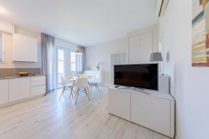 eine Küche und ein Wohnzimmer mit einem Flachbild-TV in der Unterkunft Appartamento Valeria by Wonderful Italy in Sirmione