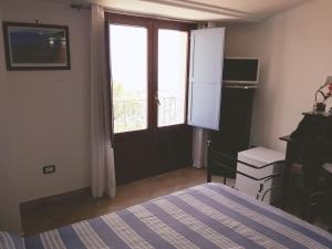 a bedroom with a bed and a door with a window at B&B La Civetta in Agropoli