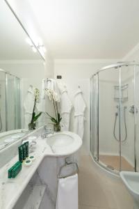 a white bathroom with a sink and a shower at Hotel Barchetta Excelsior in Como