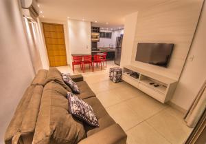 a living room with a couch and a flat screen tv at Luxor Paulo Miranda By Penareia in João Pessoa +85 photos