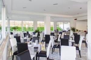 a dining room with white tables and chairs at Hotel Villa Chiara in Terracina