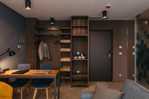 a room with a table and chairs and a closet at Avena Boutique Hotel by Artery Hotels in Kraków
