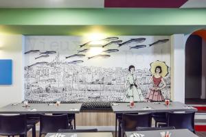 mural en la pared de un restaurante con mesas y sillas en ibis Styles Marseille Vieux Port en Marsella