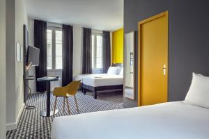Habitación de hotel con 2 camas y puerta amarilla en ibis Styles Marseille Vieux Port en Marsella