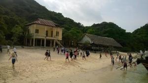 a group of people playing a game on a beach at Homestay Thanh Long in Cat Ba
