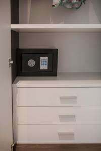 a clock sitting on top of a white dresser at Residenza Angelica in Lazise