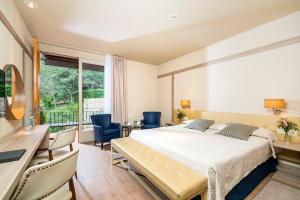 a bedroom with a bed and a desk and chairs at Hotel Santa Marta in Lloret de Mar