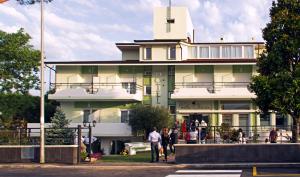 a large yellow building with people standing outside of it at Hotel Villa Chiara in Terracina