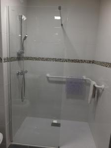 een douche met een glazen deur in de badkamer bij Résidence Thermale du Parc in Ornolac-Ussat-les-Bains