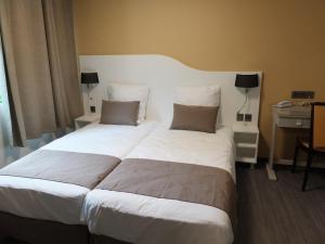 Ornolac-Ussat-les-BainsにあるRésidence Thermale du Parcのホテルルーム内の大きな白いベッド