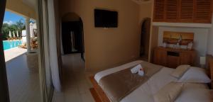 a bedroom with a bed and a television and a pool at Villa Torrella in Mezzavia