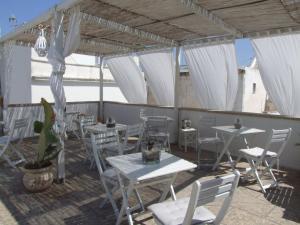 ガリポリにあるCorte Molineの白いテーブルと椅子、白いカーテンが備わるレストラン