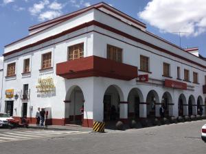 Atlacomulco de Fabela的住宿－Mansion de los Abuelos，一座白色和红色的建筑,前面的人站在