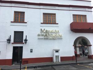 Atlacomulco de Fabela的住宿－Mansion de los Abuelos，白色的建筑,旁边标有标志