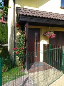 ein Haus mit einem Tor und einer Tür mit Blumen in der Unterkunft Apartament Słoneczny in Danzig