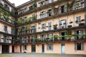 un immeuble d'appartements avec des plantes en pot sur les balcons dans l'établissement Residenza Porta Romana, à Milan