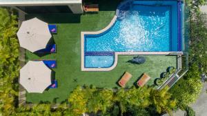 einen Blick über einen Pool mit Sonnenschirmen in der Unterkunft Sea View Luxury Villas Kata Beach in Kata Beach