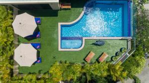 eine Draufsicht auf einen Swimmingpool mit Sonnenschirmen in der Unterkunft Sea View Luxury Villas Kata Beach in Kata Beach