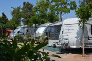 a row of three rvs parked in a lot at Camping Valencia el Saler in El Saler