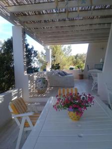 a patio with a table and chairs and flowers at Villa Biancaluna in Carloforte