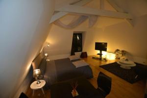 a bedroom with a bed and a living room at Maison d'hôtes Les Coudreaux in Rueil-Malmaison