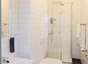 a white bathroom with a shower and a toilet at Fosshotel Eastfjords in Fáskrúðsfjörður +36 photos