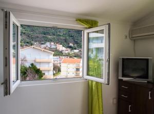 a room with a large window and a television at Villa Palma Ceoce in Budva