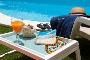 einen Tisch mit einem Buch und ein Glas Orangensaft in der Unterkunft Lilies Villa - BlueSea in Albufeira