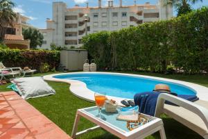 a man sitting in a chair next to a pool at Lilies Villa - BlueSea in Albufeira