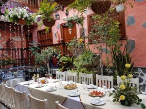a table with white tables and chairs in a garden at Fonda Central in Adeje