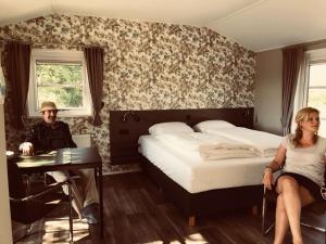 a man and a woman sitting in a room with a bed at Resort Land & Zee in Scharendijke