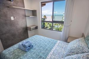 - une chambre avec un lit et une vue sur l'océan dans l'établissement Luxor Paulo Miranda Home Service, à João Pessoa