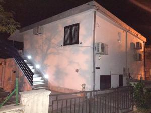 - un bâtiment blanc avec une porte et des escaliers la nuit dans l'établissement Apartman Dado, à Cres