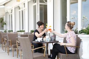 Deux femmes assises à une table sur un patio avec des boissons dans l'établissement Hotel Lungomare, à Cattolica