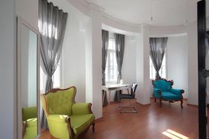 a room with chairs and a table and windows at Hostel Musala in Varna City