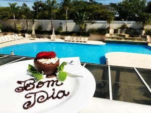 uma sobremesa num prato ao lado de uma piscina em Itu Plaza Hotel em Itu