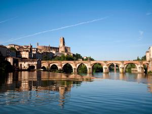 a bridge over a river with a city in the background at Les Trois Hiboux in Crespin