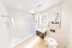 a white bathroom with a sink and a toilet at Ivory Lodge in Reading