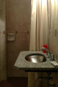 y baño con lavabo y ducha. en Hotel San Martin en Buenos Aires