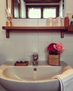 un lavandino in bagno con un cesto di fiori di Cascina Bertolotto Wine Resort a Spigno Monferrato