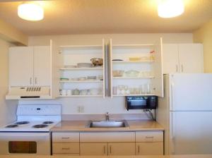 a kitchen with a sink and a white refrigerator at Waikiki Sunset Apartment in Honolulu
