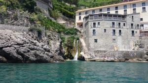 a waterfall in a body of water next to a building at Via Trento 30 in Salerno