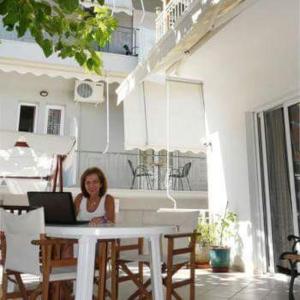 a woman sitting at a table with a laptop at Thalia Hotel in Kamena Vourla