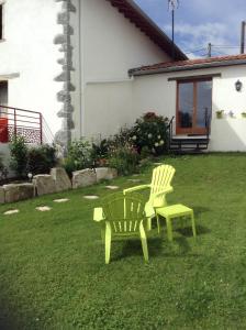 two chairs and a table in a yard at Gite Larrondoa in Saint-Esteben