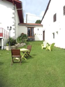 a yard with a table and chairs and a building at Gite Larrondoa in Saint-Esteben