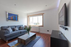 uma sala de estar com um sofá e uma televisão em Leys Park Executive Apartments em Dunfermline