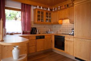 a kitchen with wooden cabinets and a stove top oven at Eggerhof - Ferienhaus in Ramsau am Dachstein