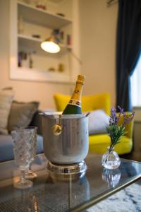 Una botella de champán en un cubo sobre una mesa en Willoughby Apartment, en Bath