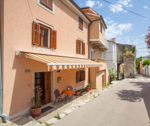 a house with a table and chairs outside of it at Apartment Rialto with private parking in Cres