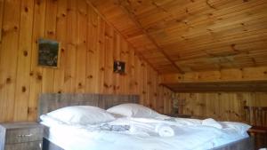 a bed in a room with a wooden ceiling at Lagami house in Mestia